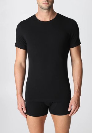 T-shirt nero a maniche corte realizzato in tessuto liscio e elastico, con un design aderente e colletto rotondo, abbinato a pantaloni corti neri aderenti.