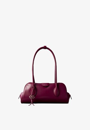 Pequeño bolso de mano de cuero burdeos con asas largas, etiqueta con el logo de Calvin Klein y charm metálico decorativo en la correa.