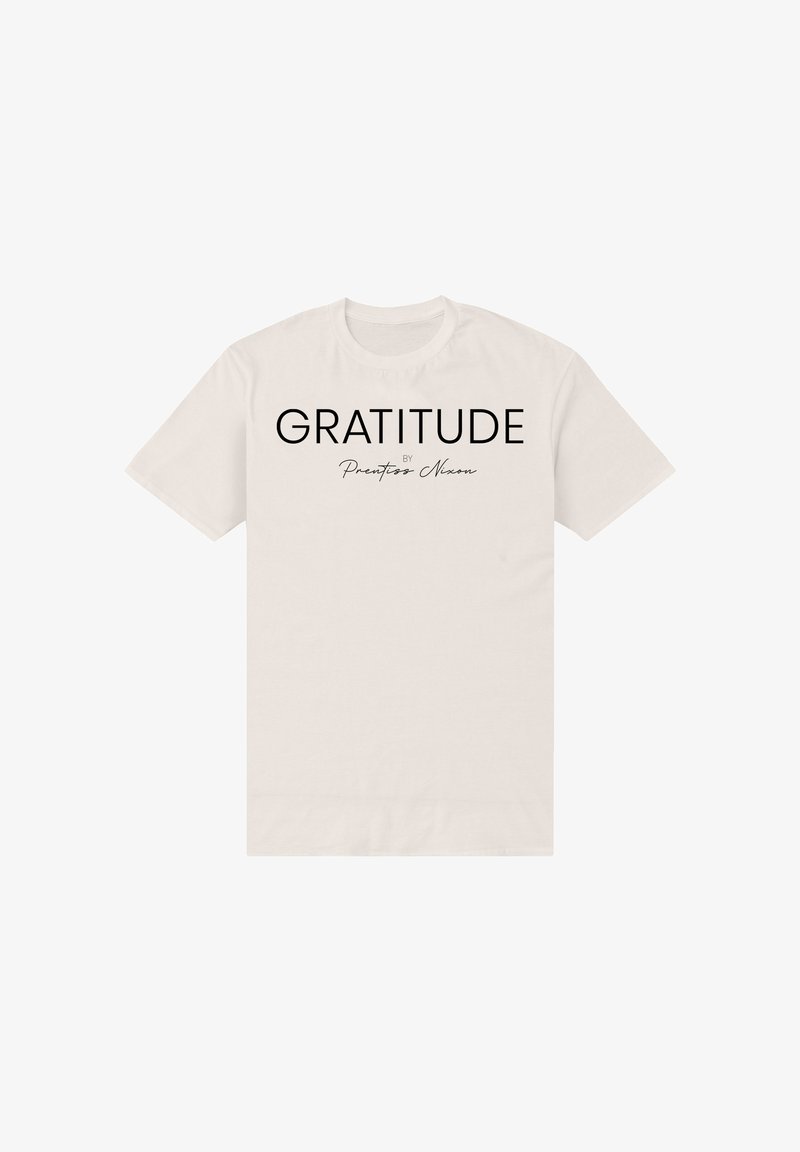 T-shirt beige à manches courtes avec l'inscription "GRATITUDE par Prentiss Nixon" imprimée en noir au centre devant.