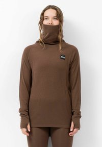 Chemise marron à manches longues avec un col haut, texture côtelée et trous pour les pouces aux poignets. Présente un petit logo noir sur la poitrine.