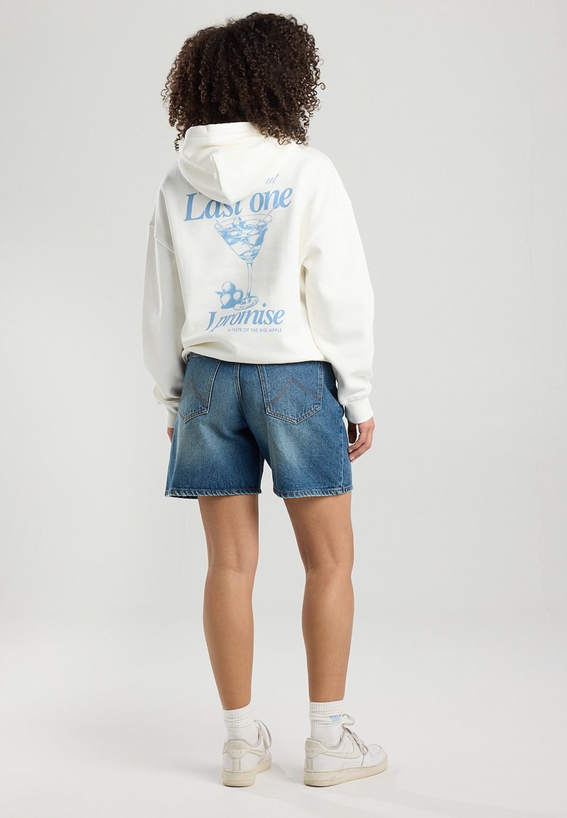White hoodie with blue graphic of a cocktail glass and text on the back, paired with blue denim shorts. Casual fit, medium length.
