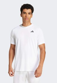 White athletic t-shirt made of lightweight fabric, featuring short sleeves and a round neckline. Small black logo on the left chest.