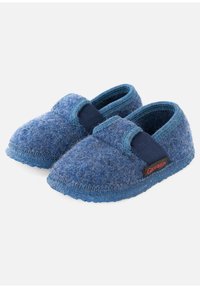 Een paar blauwe wollen slippers met gestructureerde zolen en elastische banden over de bovenkant, gemarkeerd met een rode en zwarte Giesswein-label.