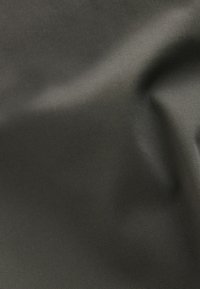 Tissu lisse gris foncé avec une fine texture diagonale et des plis doux créant des ombres et des reflets subtils.