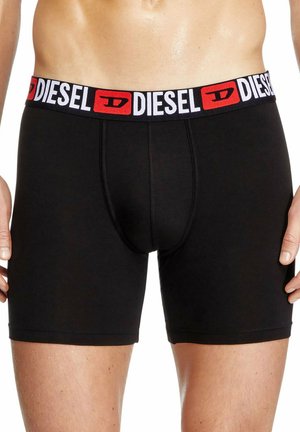 Schwarze Boxershorts aus dehnbarem Stoff, mit einem breiten elastischen Bund, auf dem das "DIESEL"-Logo in Rot und Weiß abgebildet ist.