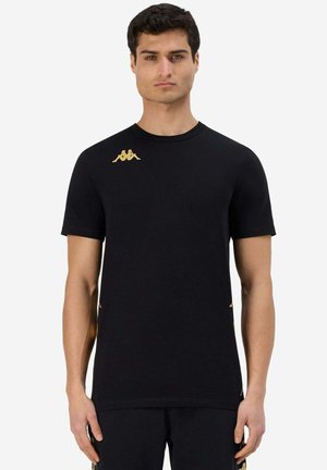 T-shirt corto nero a maniche corte in cotone con collo rotondo, caratterizzato da un logo oro sulla spalla sinistra e dettagli laterali.