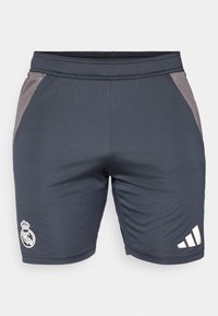 Shorts atletici grigio scuro con una consistenza liscia, dotati di un logo bianco del Real Madrid a sinistra e strisce bianche Adidas sul lato destro.