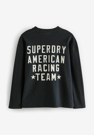 Juoda ilgomis rankovėmis marškinėliai su balta spauda "SUPERDRY AMERICAN RACING TEAM" ir žvaigždėmis, pagaminti iš medvilnės, standartinio kirpimo.