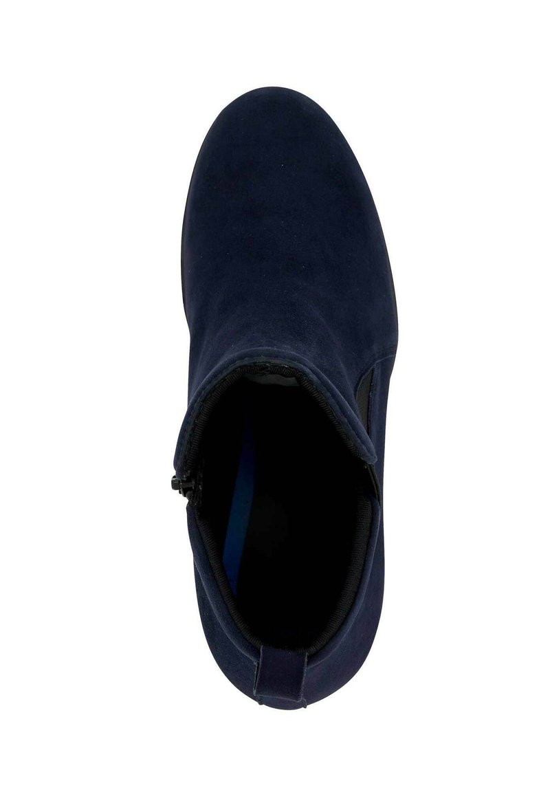 Bottine bleu marine en suède doux, avec un bout rond, fermeture éclair sur le côté, et un panneau élastique noir pour un enfilage facile.