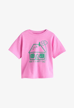 Lyserød kortærmet skjorte med grønt hus illustration, smilende ansigt, blomst og teksten "HJEM ER MIT GLADPLADS" på fronten.