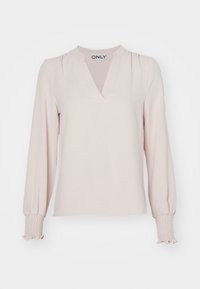 Ljusrosa långärmad blus med V-halsringning, sammanknippade axlar och smockade manschetter. Mjuk tyg med en slät yta.