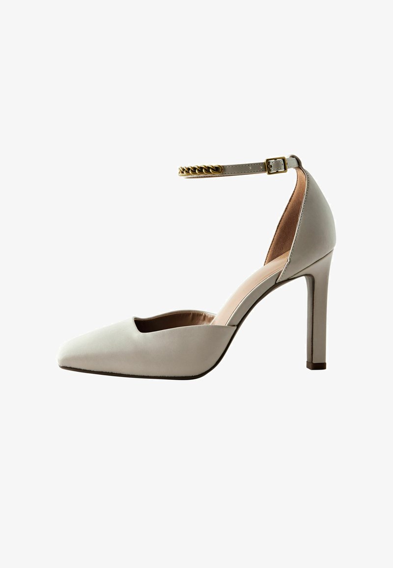 Light gray high-heeled shoe with a pointed toe, open vamp design, ankle strap, and gold chain accent. Smooth leather texture.