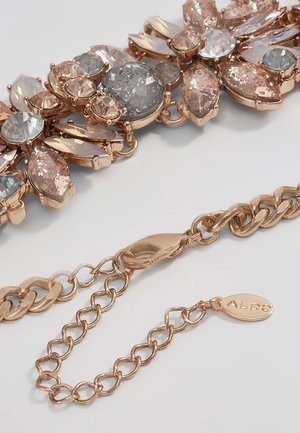 Collier chaîne en or rose avec des grappes en forme de fleur de pierres précieuses facettées roses, grises et transparentes et un fermoir mousqueton avec une étiquette ALDO.