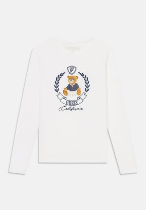 Long-sleeve white T-shirt featuring a cartoon bear in a navy outfit, surrounded by laurel branches and “Guess California” text.