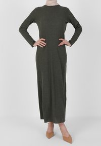 Longue robe côtelée vert olive avec manches longues et col rond, fabriquée dans un matériau doux. Présente une coupe ajustée et s'étend jusqu'aux chevilles.