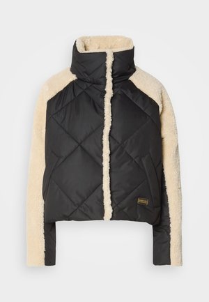 Casaco puffer preto acolchoado com mangas e colarinho de pelugem sintética creme. Possui fecho de correr, bolsos laterais e etiqueta da marca na parte inferior.