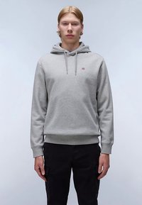 Grå hættetrøje med snøre, ribbet kant og ærmer, med en lille logo på brystet. Bruges sammen med sorte cargobukser.