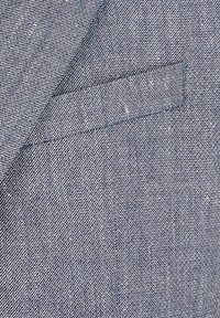 Marineblaue Stoff mit einer strukturierten Webart; verfügt über einen taillierten Kragen mit einer dezenten aufgesetzten Tasche. Minimalistisches Design mit sauberem Finish.