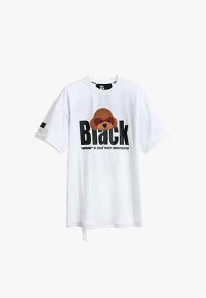 Camiseta de algodón blanca con una aplicación de la cabeza de un oso marrón texturizada y un texto en negrita negro que dice "Black" con letras más pequeñas debajo.