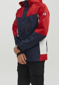 Veske veskuvat jacket, jossa on väriblokki design punaisessa, laivastonsinisessä ja valkoisessa, edessä vetoketju ja nappikiinnitys hupussa. Sisältää sivutaskut.