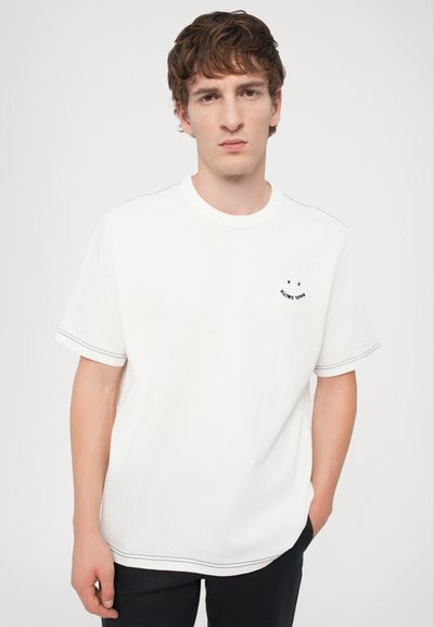 White cotton t-shirt with short sleeves, featuring contrasting black stitching and a small black graphic on the chest.