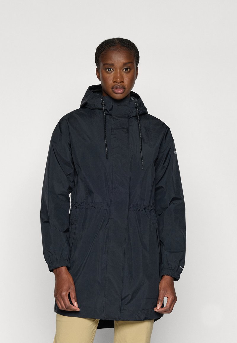 Manteau de pluie noir léger avec capuche, taille réglable par cordon, poignets élastiques et fermeture éclair à l'avant. Tissu lisse et résistant aux intempéries.