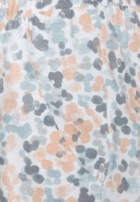 Cotton fabric with scattered floral pattern in beige, gray, and teal. Features a side pocket and elastic waistband for comfort.