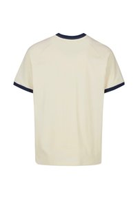 Světle krémové tričko s tmavě modrým žebrovaným límečkem a manžetami rukávů. Krátké rukávy a uvolněný střih, vyrobeno z měkké látky.