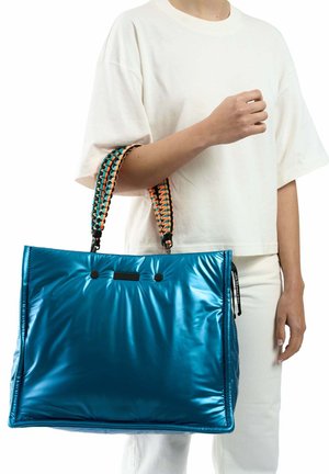 Blauwe, glanzende, oversized draagtas met een gevoerd ontwerp en gevlochten meerkleurige handvatten. Heeft zwarte accenten en bovenste drukknoopsluitingen.