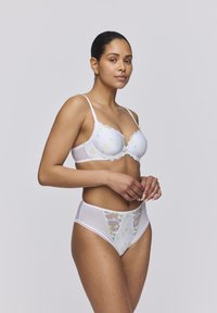 Reggiseno bianco e mutandine a vita alta con ricami floreali e bordi in pizzo. Il materiale è trasparente e dalla texture morbida, con dettagli delicati.