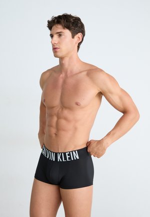 Zwarte boxer briefs met een witte "CALVIN KLEIN" logo op de tailleband, met een gladde textuur en een aangesloten ontwerp.