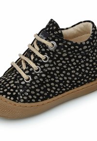 Sneaker nera con pois dorati, materiale in velluto, suola in gomma beige, punta rotonda e design con lacci, con lacci e occhielli color oro.
