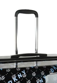 Maleta rígida negra con acabado brillante, adornada con los logotipos de DKNY en azul y blanco, que cuenta con un asa metálica retráctil y cierre de cremallera.