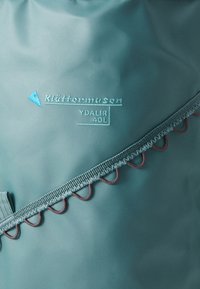 40L waterproof backpack in dark teal, featuring a contrasting blue logo and decorative red stitching along the strap and zippers.