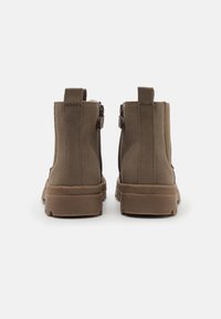Brązowe botki za kostkę wykonane z gładkiego materiału syntetycznego, z teksturowaną gumową podeszwą, wyposażone w podwójne zamki błyskawiczne po bokach oraz pętelki do zakupu.