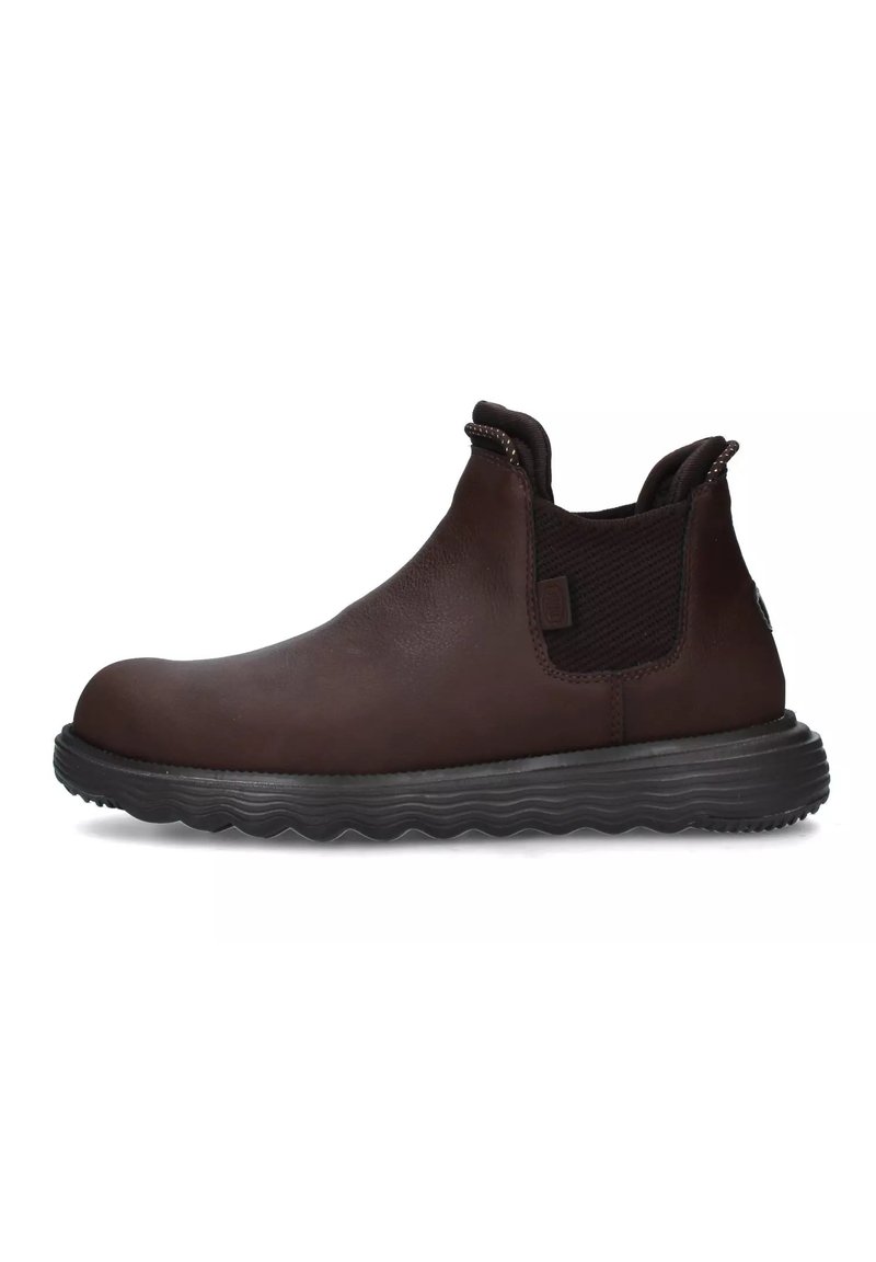 Stivali ankle in pelle marrone con pannelli laterali elastici, punta arrotondata e suola in gomma nera testurizzata con motivo a onda.