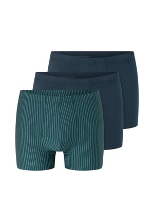 Tři páry pánských boxerových trenýrek, dva jednobarevné tmavě modré a jeden zelený s tenkými bílými svislými pruhy, uspořádané vedle sebe.