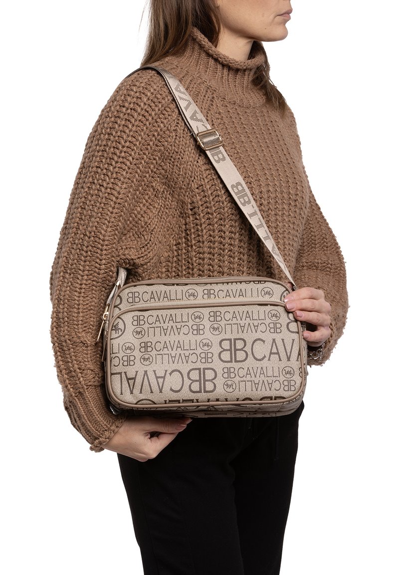 Borsa crossbody beige con loghi stampati, chiusura con zip e tracolla decorata. Realizzata in resistente materiale di tela con una finitura liscia.