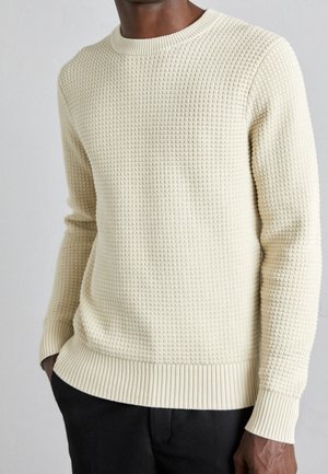 Cremfarbener, strukturierter Pullover mit Waffelmuster, gerippten Bündchen und Saum sowie einem klassischen Rundhalsdesign.
