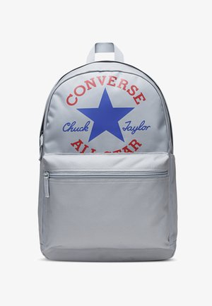 Szürke hátizsák kék csillaggal és piros szöveggel, amely "CONVERSE" és "Chuck Taylor" feliratokat visel, elülső cipzáros zsebbel. Szintetikus anyagból készült.