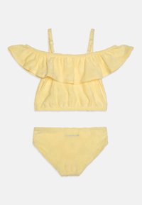 Gul to-delt badedragt med en off-the-shoulder top med flæse og blomster mønster, samt matchende bikini underdele med logo detalje.