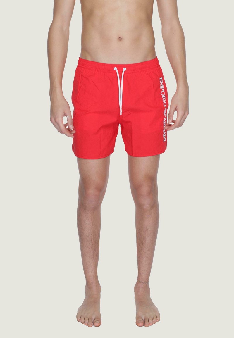 Pantaloni da bagno rossi con cintura regolabile, realizzati in un tessuto testurizzato e con logo bianco sul lato sinistro. Lunghezza fino a metà coscia. Design minimalista.