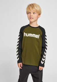 Langærmet t-shirt med olivengrøn krop, sorte raglanærmer, hvidt "hummel"-logo og chevronprint langs ærmerne. Blød bomuldsblanding.