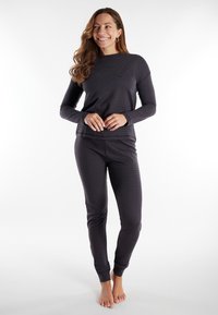 Top de manga larga gris oscuro con textura acanalada y cuello redondo; pantalones ajustados a juego con puños elásticos; diseño minimalista, sin patrones notables.