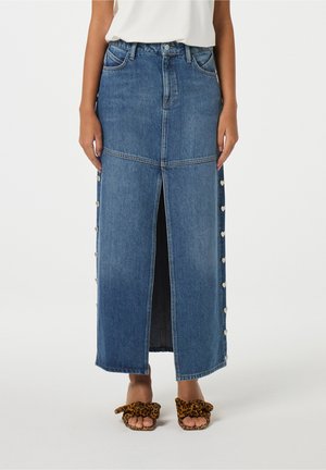 Denim maxi rok met een split aan de voorkant, lichtblauwe wassing, zilveren hartknopen aan de zijkant en een rechte pasvorm. Draag het met dierenprint slides.