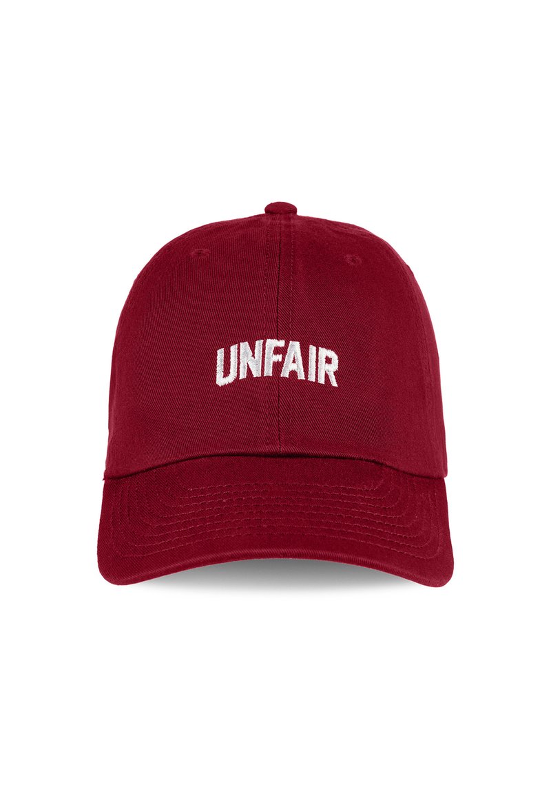 Red cotton cap with a curved visor and adjustable strap. Features "UNFAIR" embroidered in white across the front. Textured fabric.