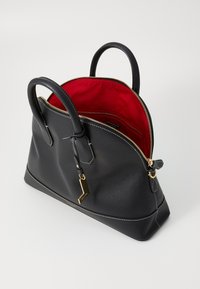 Borsa a tracolla in pelle nera con silhouette strutturata, dotata di un interno rosso, hardware dorato e dettagli in cucitura bianca. Chiusura con zip.