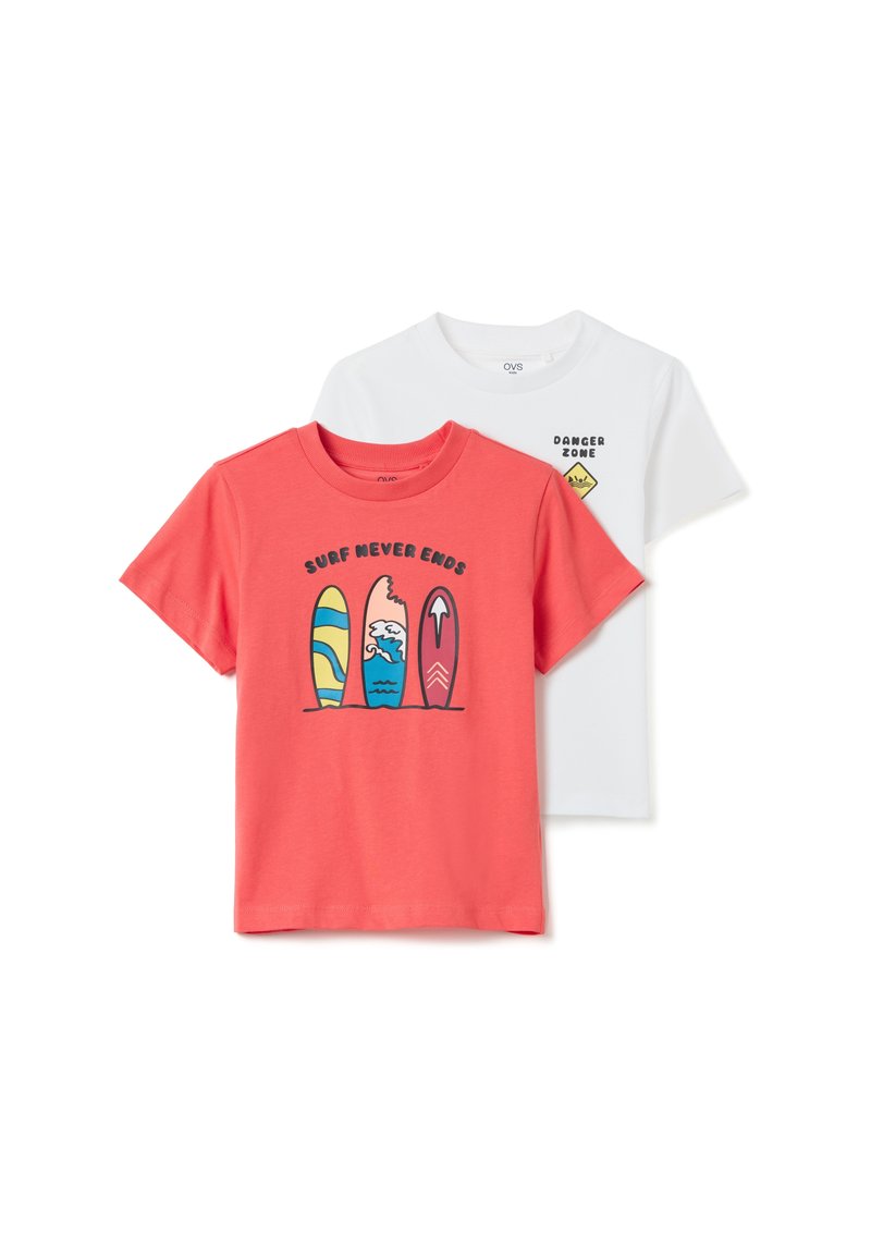 Dos camisetas: una coral con gráficos de tabla de surf y el texto "EL SURF NUNCA TERMINA", y una blanca con un diseño de señal de "ZONA PELIGROSA". Mangas cortas, de algodón.
