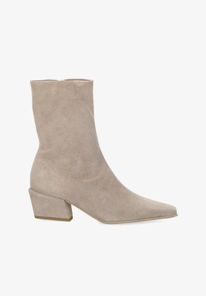 Beige suède enkellaars met puntige neus en blokhak, zijaanzicht op witte achtergrond.