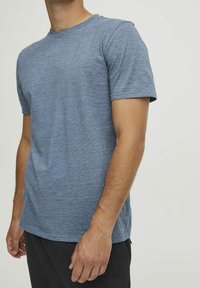 Blå melert t-skjorte med rund hals, korte ermer og en avslappet passform, laget av et mykt, lett stoff.